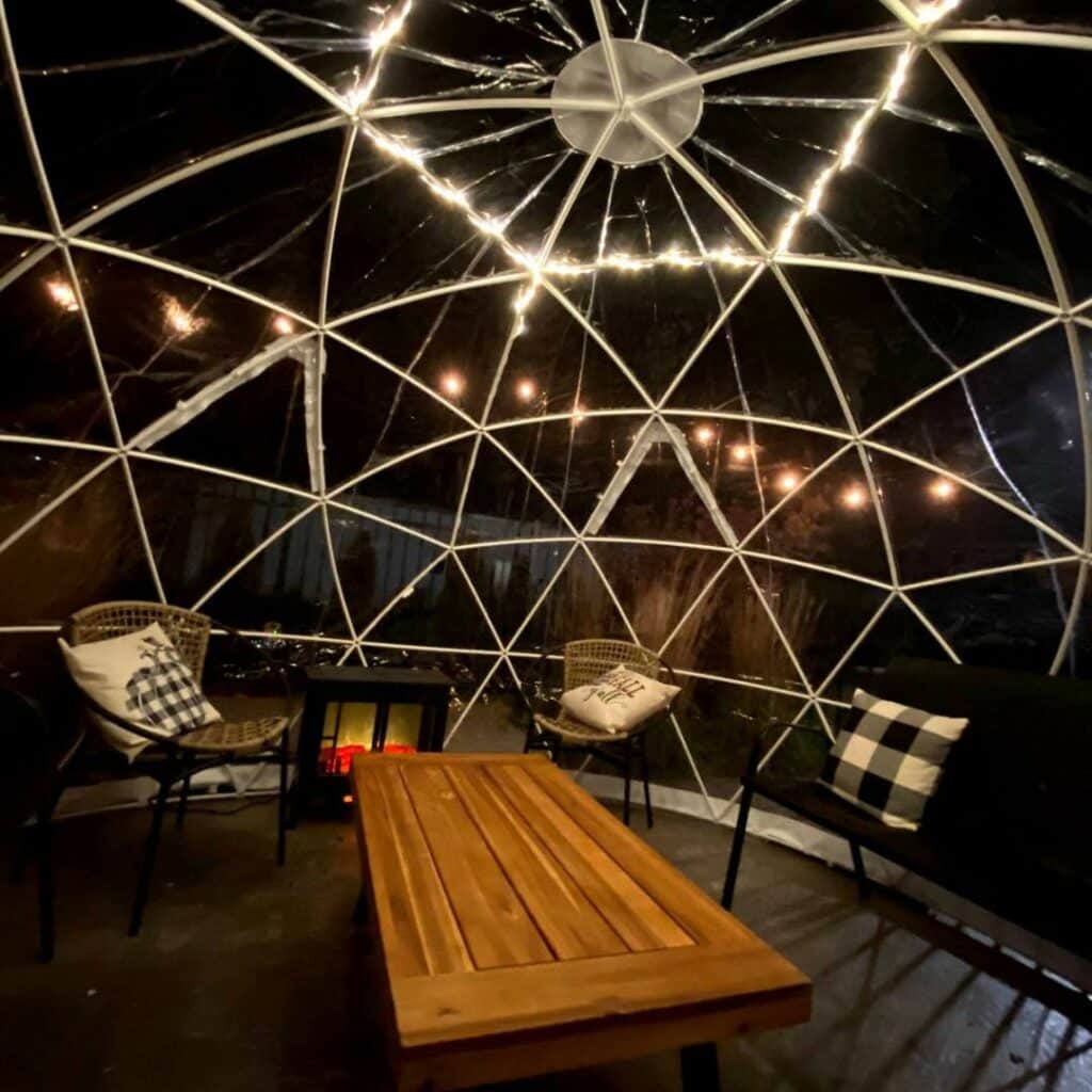 The TImber Hill Winery domes pictured with a wood table, atmospheric lights, and cozy vibes.