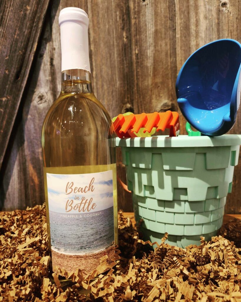 An image of Timber Hill Winer's January white wine of the month "beach in a bottle" next to a sand castle bucket.