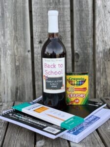 Timber Hill Winery's Wine of the Month is "Back to School Bliss", pictured with crayons, notebooks, and pencils.